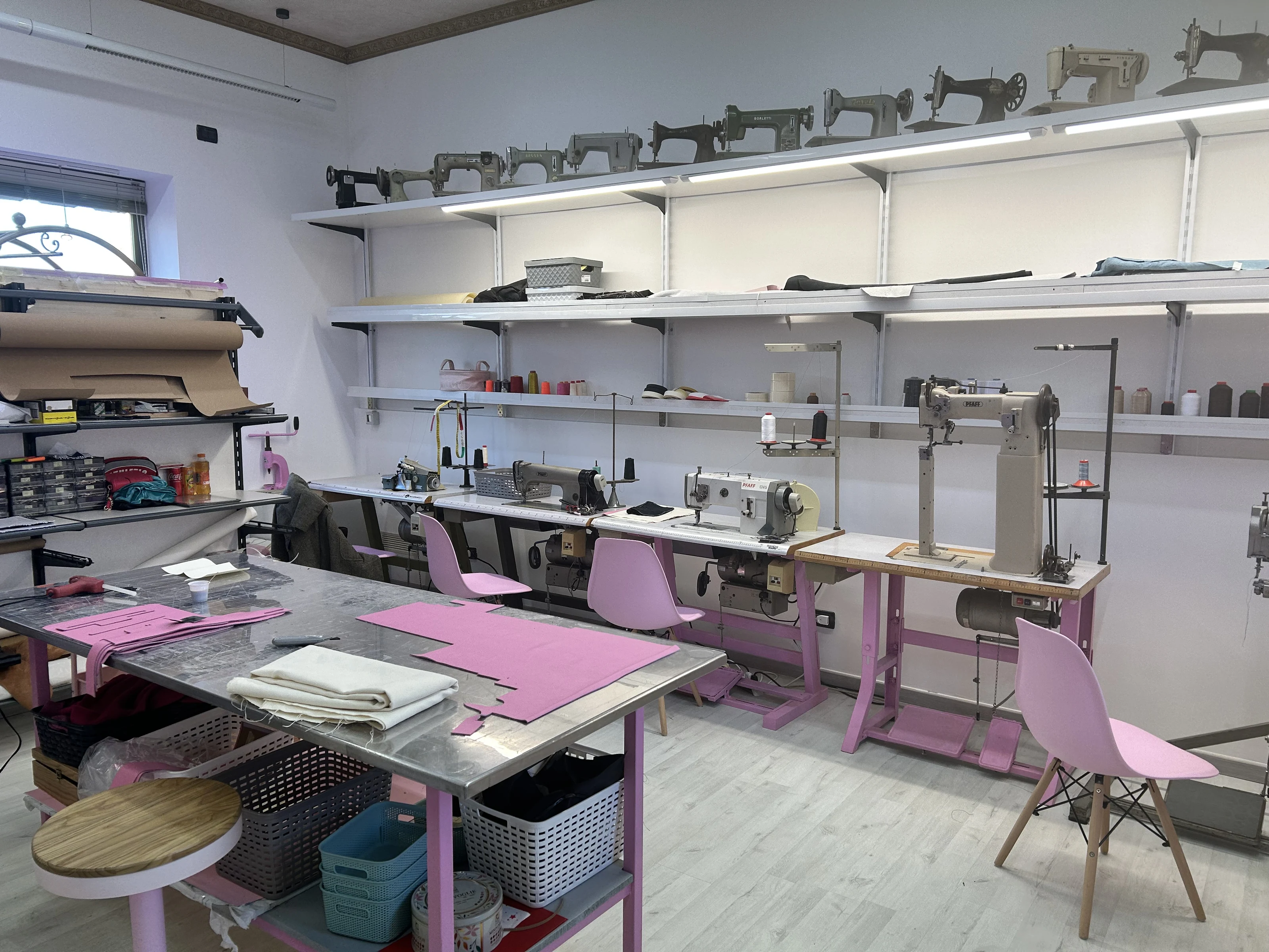 Inside the workshop, among sewing machines and materials.